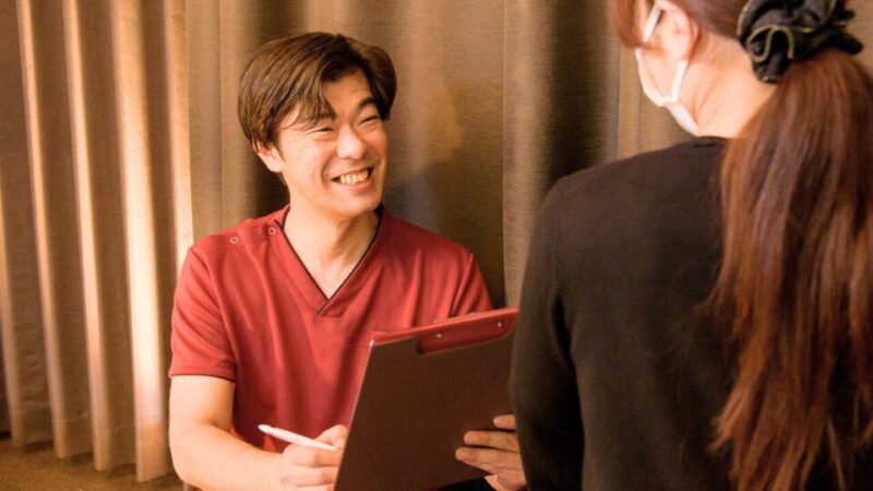 机を挟んで相談者の話を聞くポポの木院長