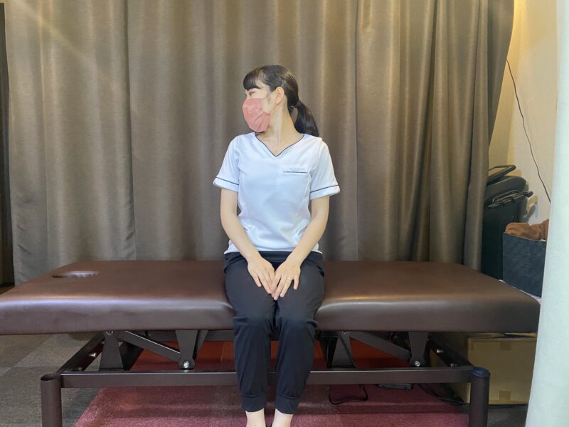 座って胸を正面に保ち、顔を横へ向ける首の運動